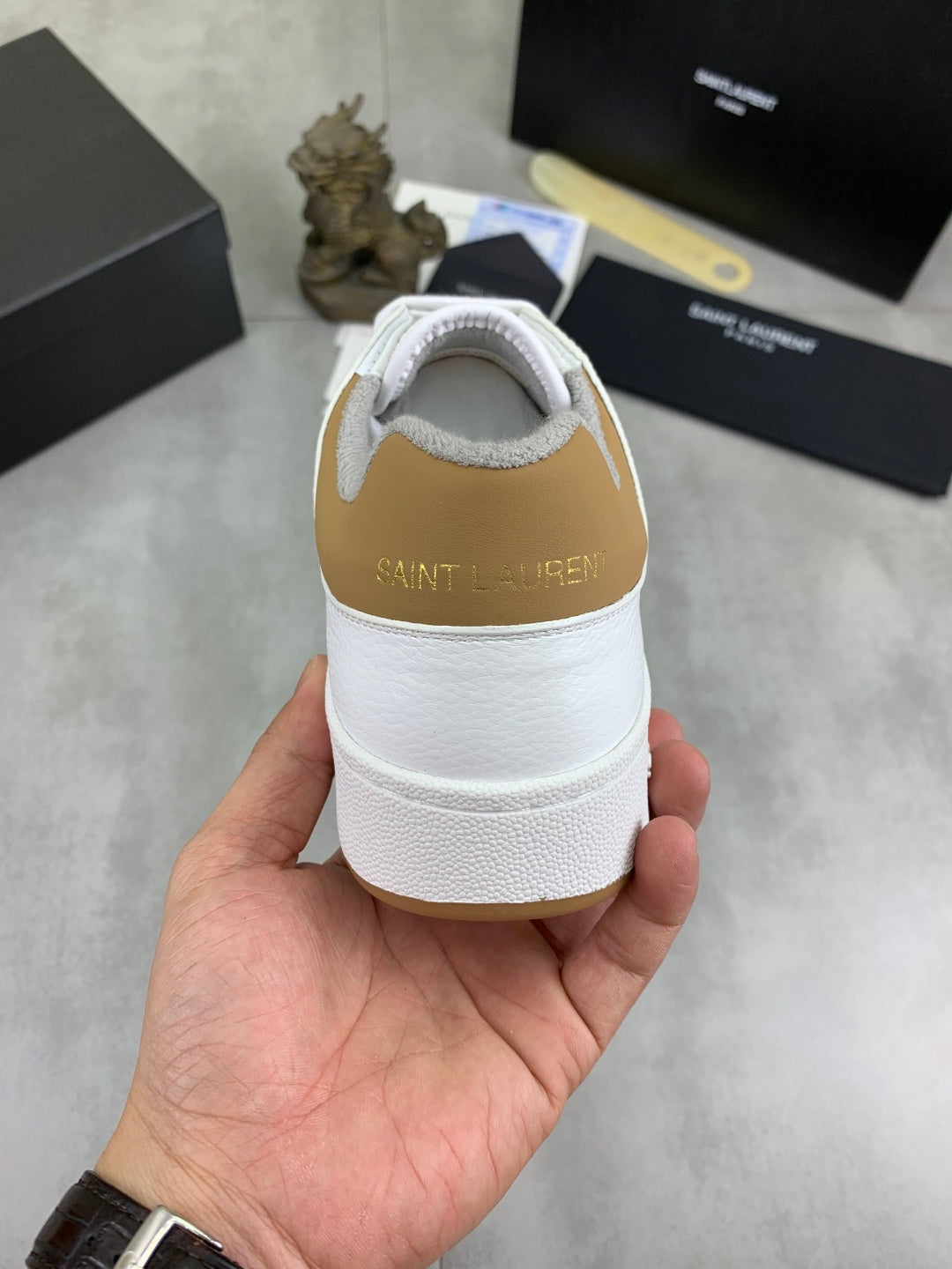 Back of white low-top sneaker with Saint Laurent logo on heel tab