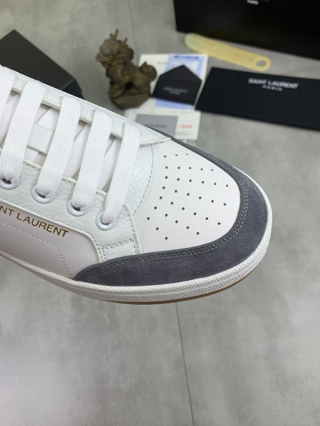 White sneaker toe cap with perforations and navy suede side panel