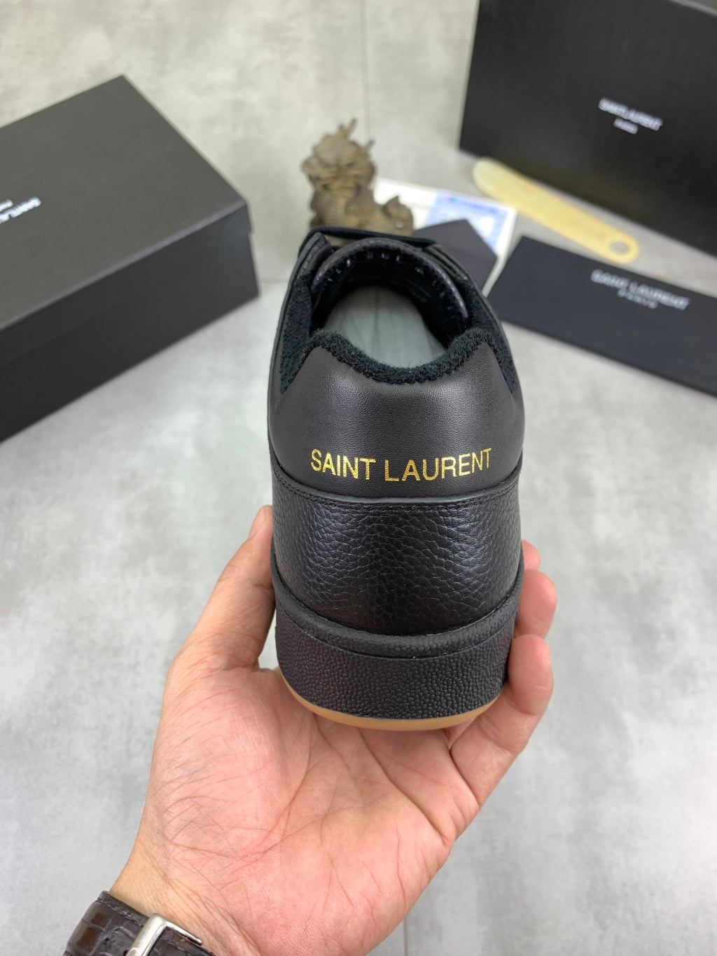 YSL unisex leather sneaker heel view, dark blue-black with “SAINT LAURENT” on back