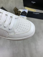 Close-up of white perforated leather sneaker toe with white laces