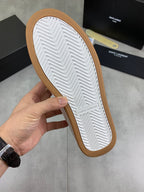 Shoe outsole view of white sneakers with textured herringbone tread