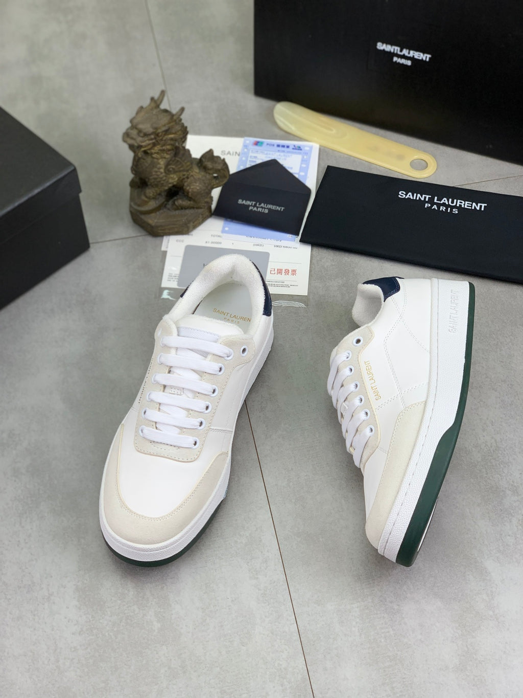 Two off-white leather sneakers with navy heel trim and white rubber sole