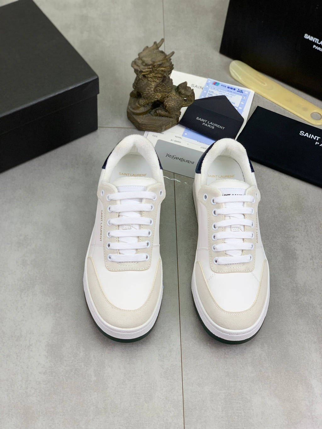 Pair of off-white leather sneakers with white laces and light trim
