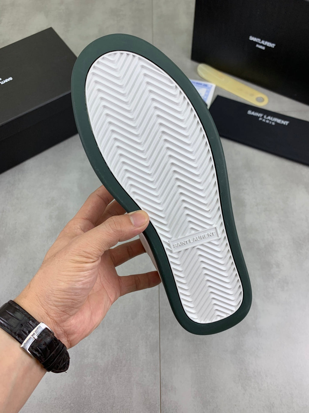 Off-white sneaker outsole with herringbone tread and green edge trim