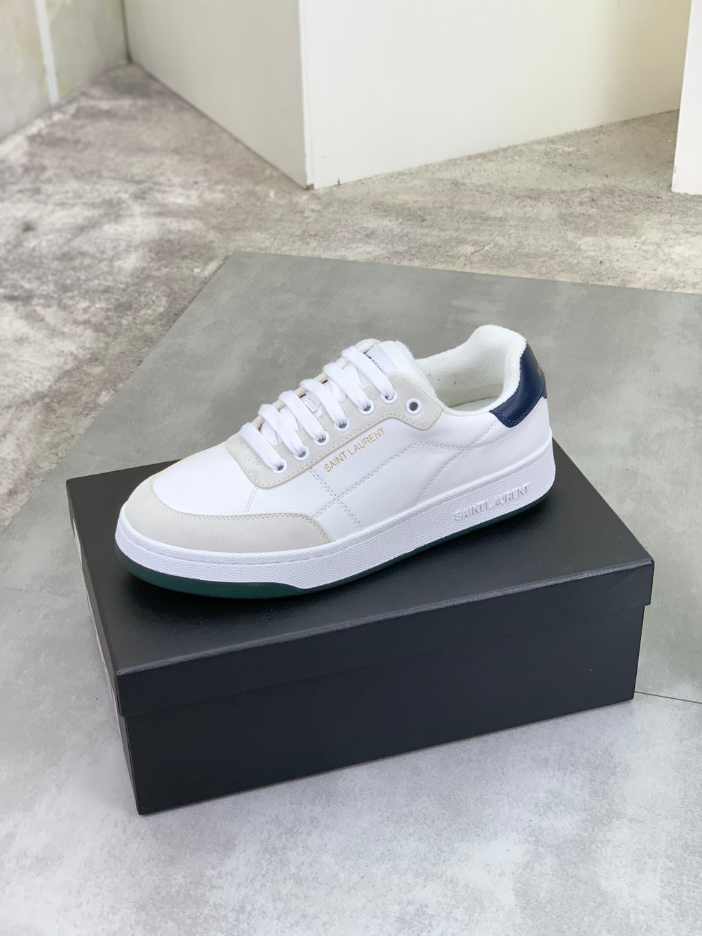 Off-white low-top leather sneaker with white laces and navy side detail
