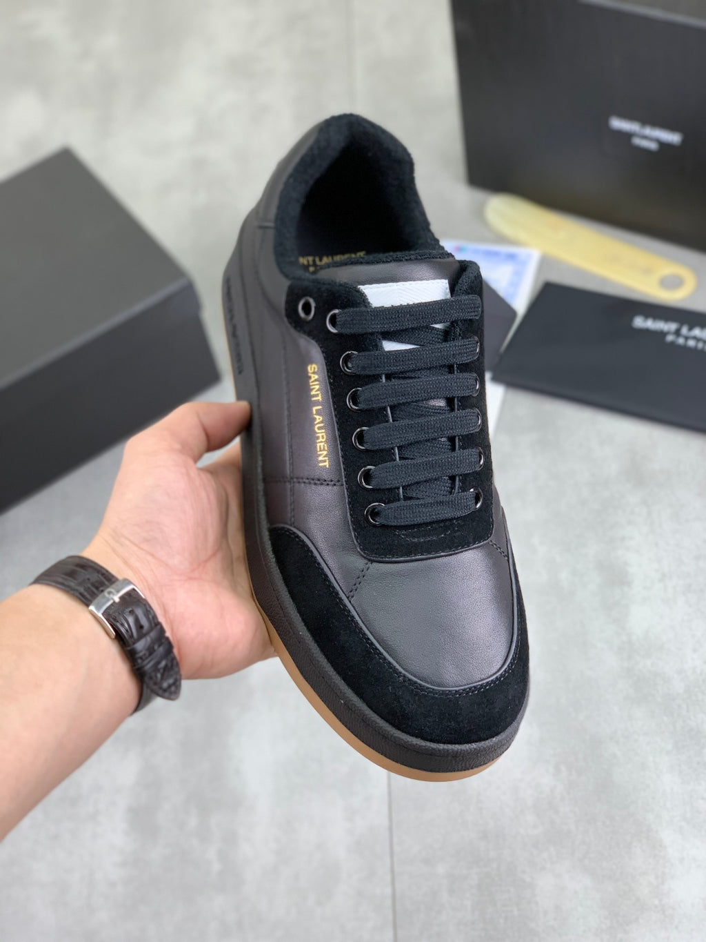 Black low-top sneakers with lace-up front and padded collar