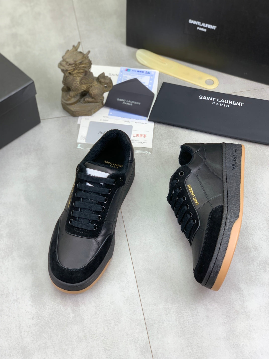 Side view of black lace-up sneakers with gum-style rubber sole