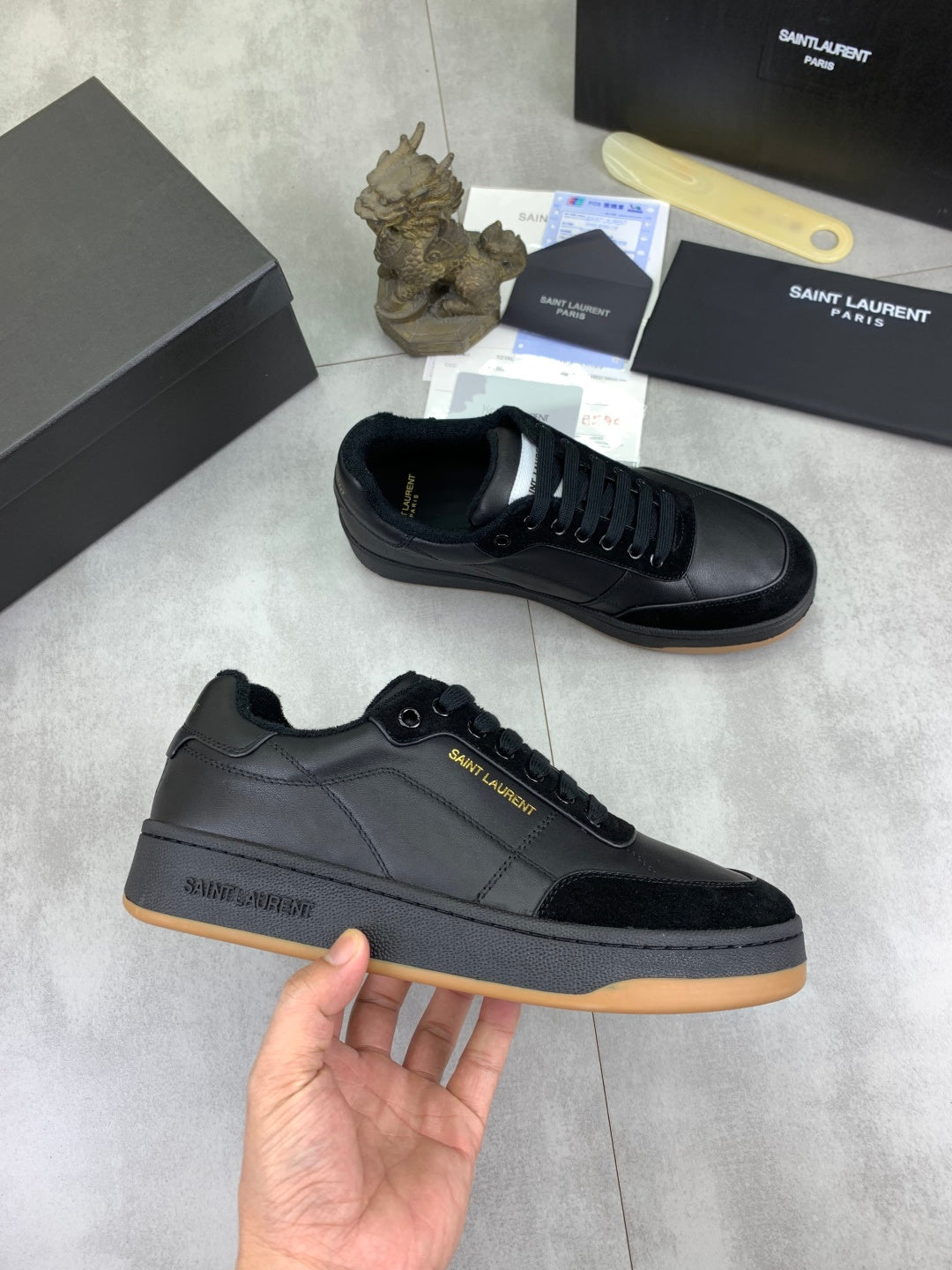 Black lace-up low-top sneakers with gum-style rubber sole