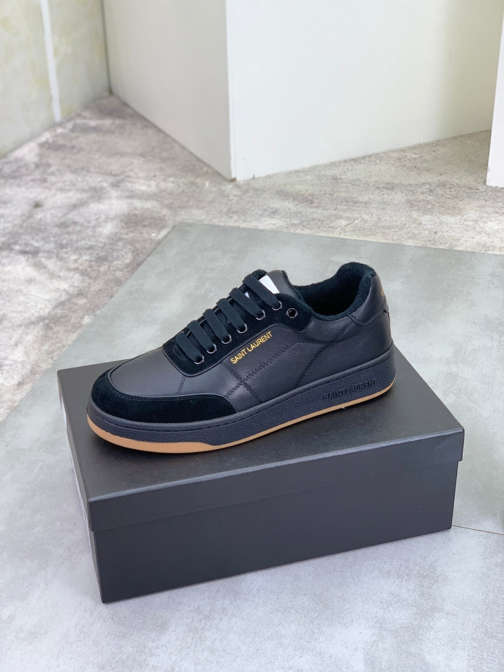 Black lace-up low-top sneakers with gum-style rubber sole
