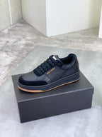 Black lace-up low-top sneakers with gum-style rubber sole