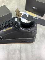 Black low-top sneakers with SAINT LAURENT logo patch and lace-up closure