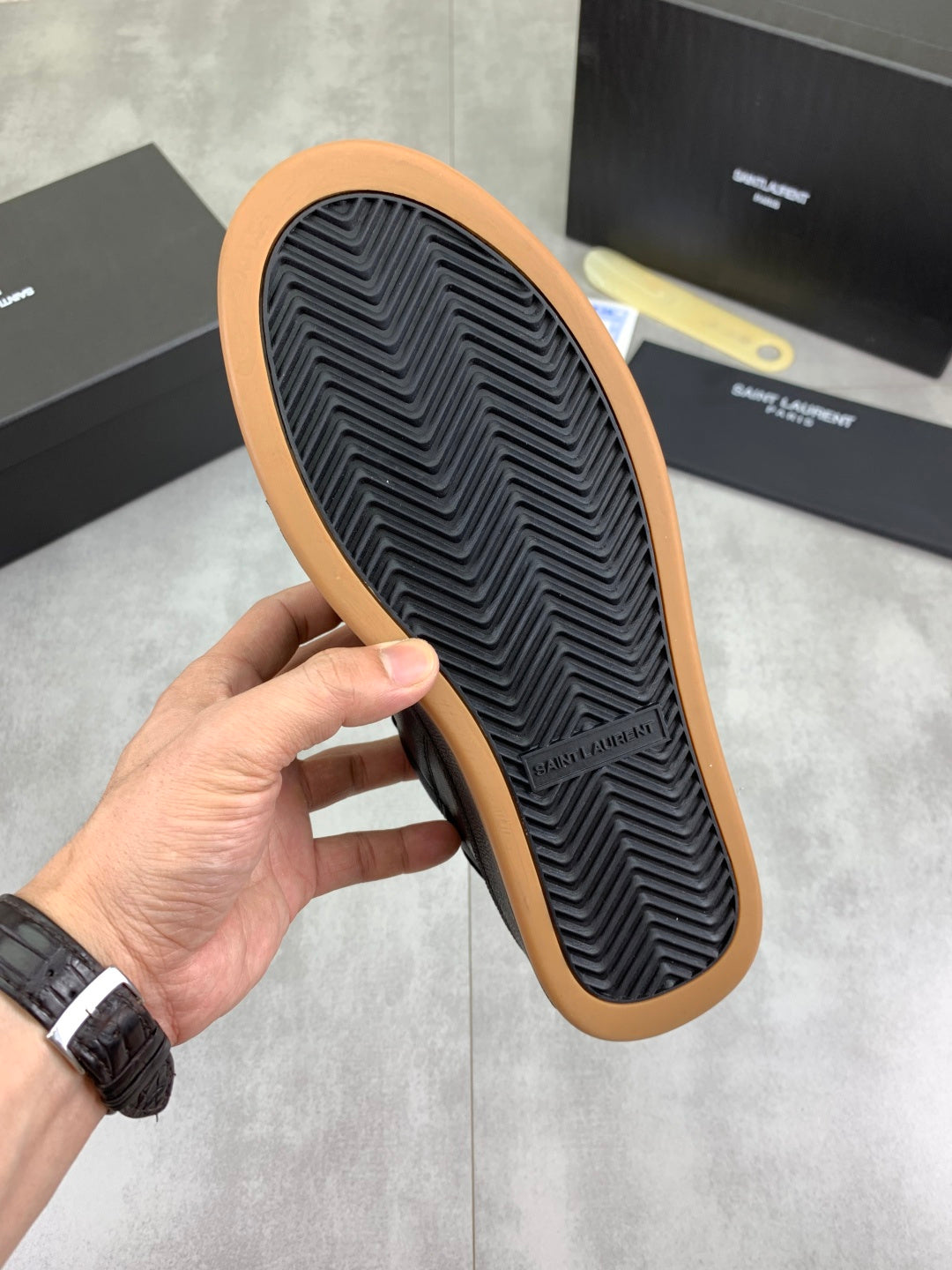 Black sneaker outsole with zigzag tread and gum rubber edge