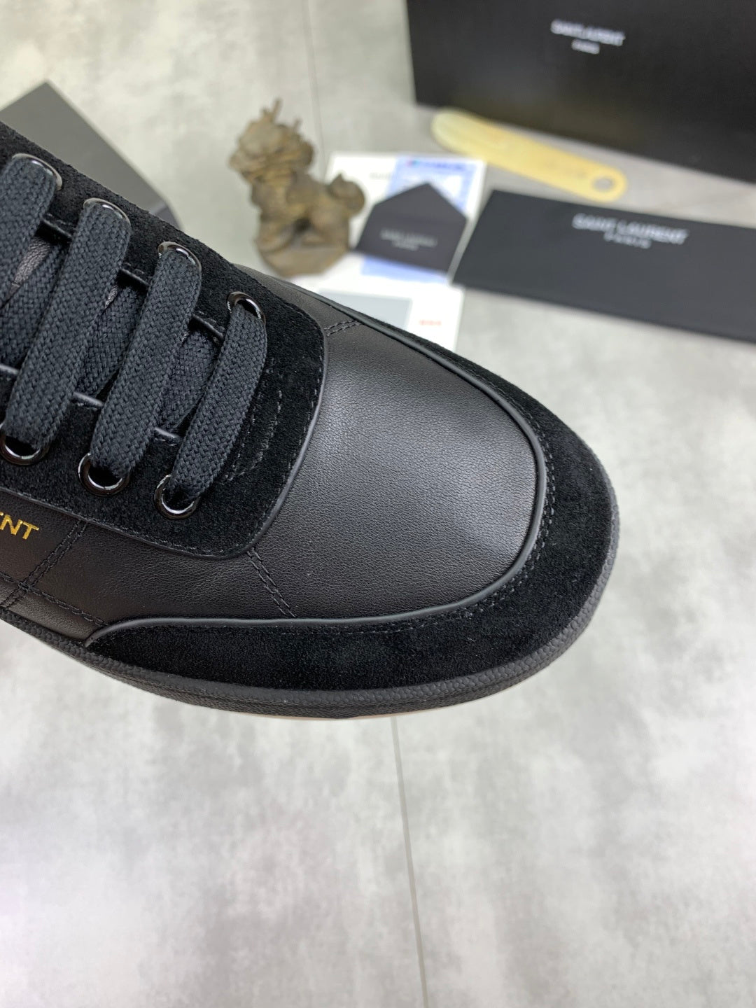 Black leather-look sneaker toe with lace-up panel and textured sole edge