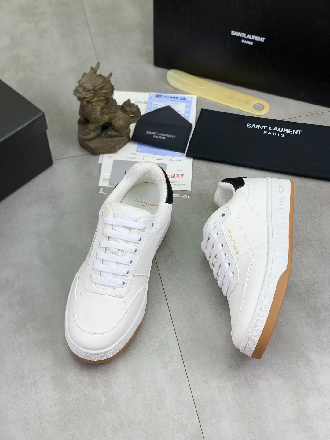 White low-top sneakers with white laces and gum soles, angled side views.