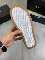 Sneaker outsole view: white tread pattern with gum-colored edge border.