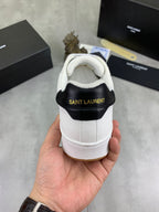 White sneaker heel with black collar and Saint Laurent text; gum sole edge.