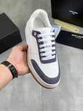 Unisex low-top sneakers, white leather with navy panels and white laces.