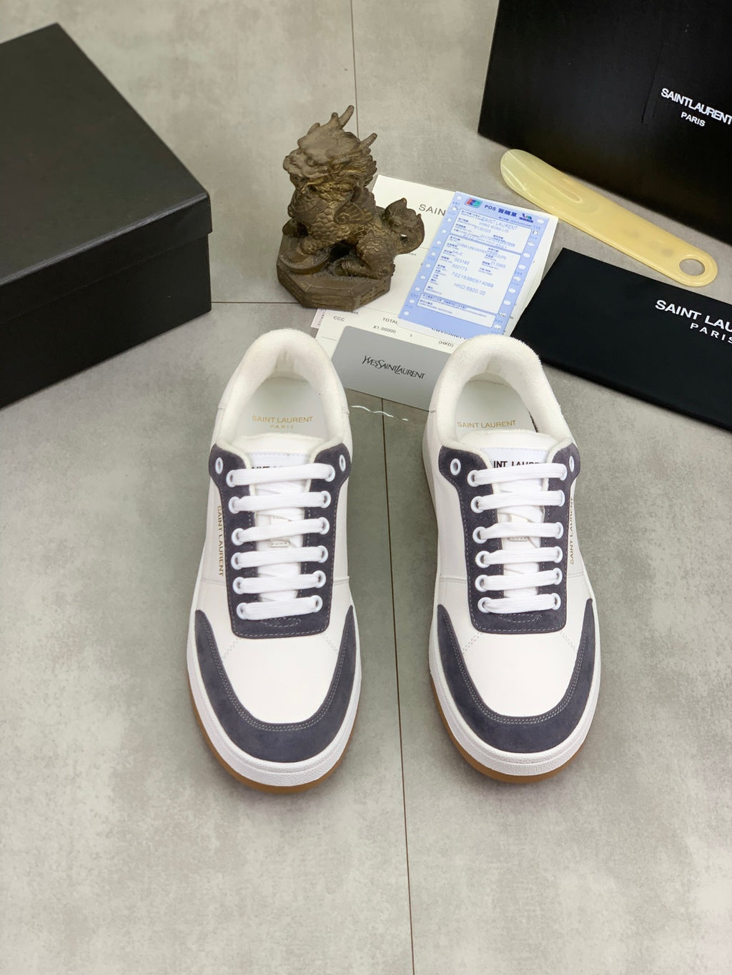 Unisex low-top sneakers pair, white uppers with navy detail and gum soles.