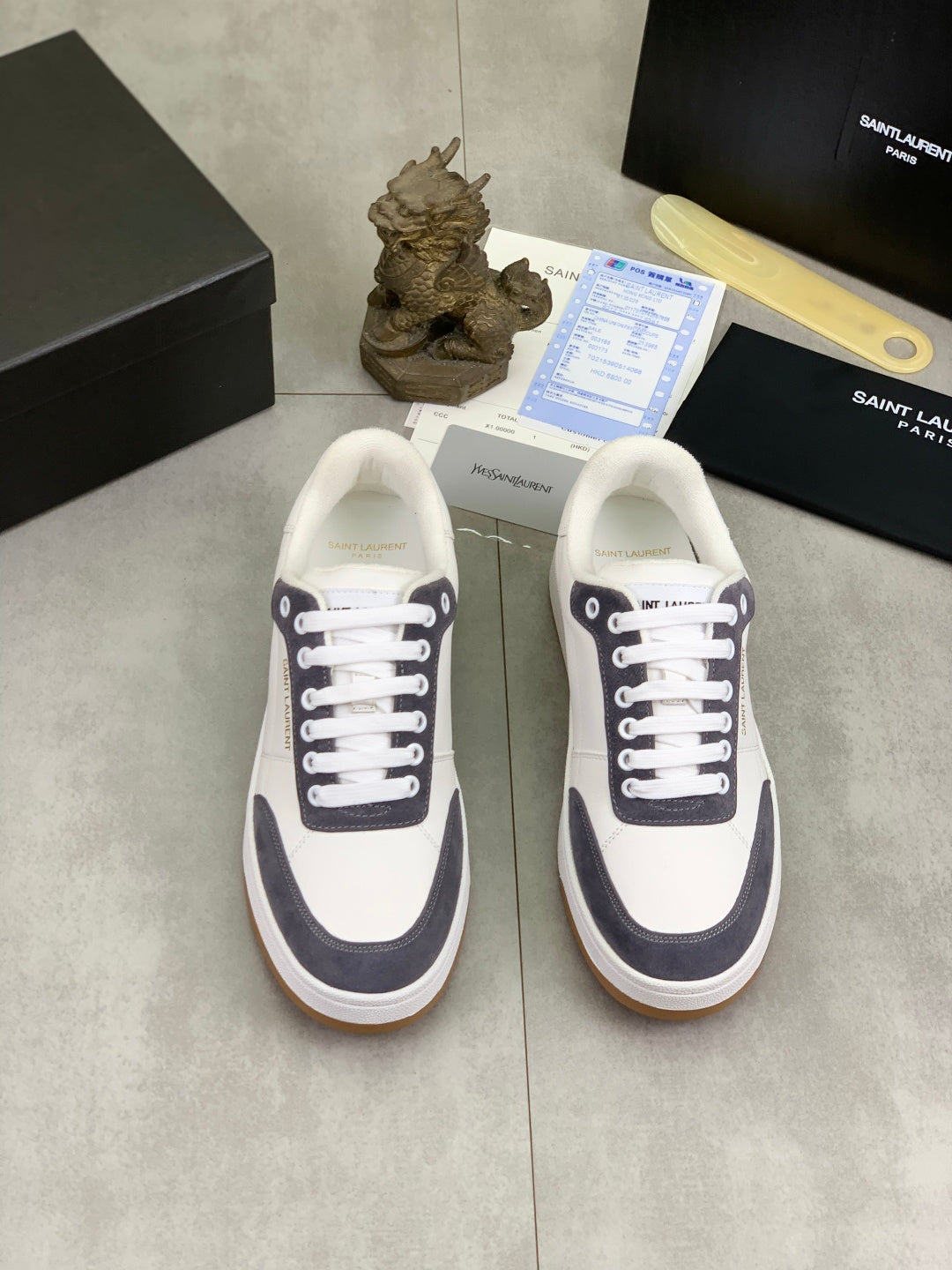 Unisex low-top sneakers pair, white uppers with navy detail and gum soles.