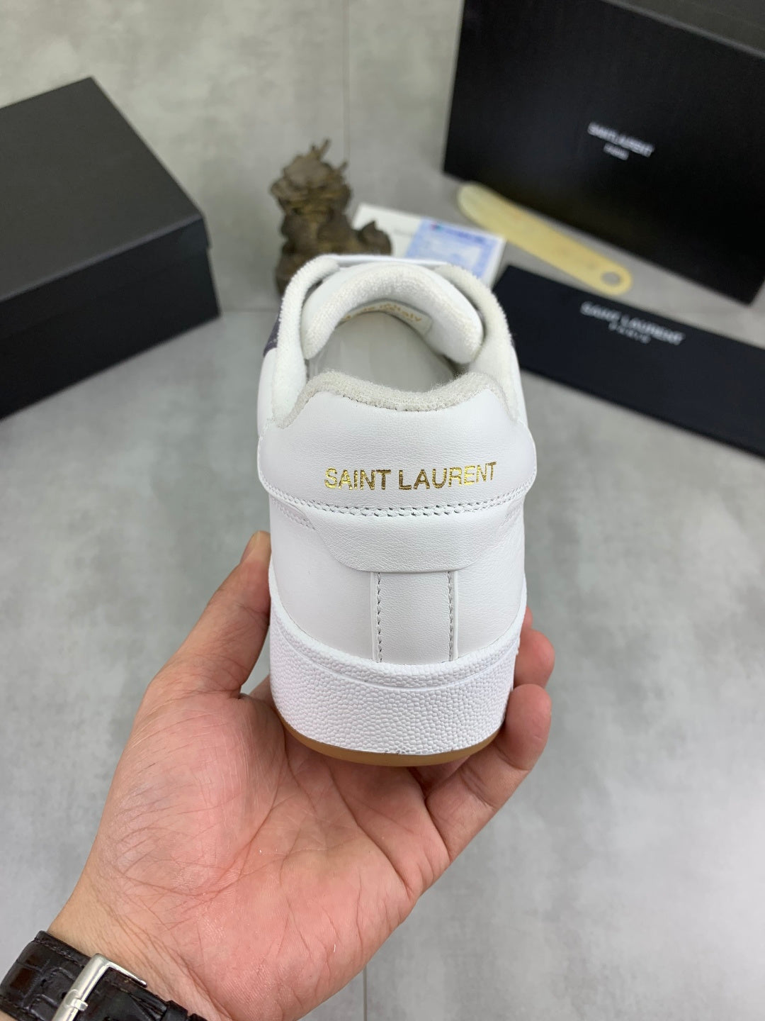 Unisex sneakers back view, white leather heel with SAINT LAURENT branding.