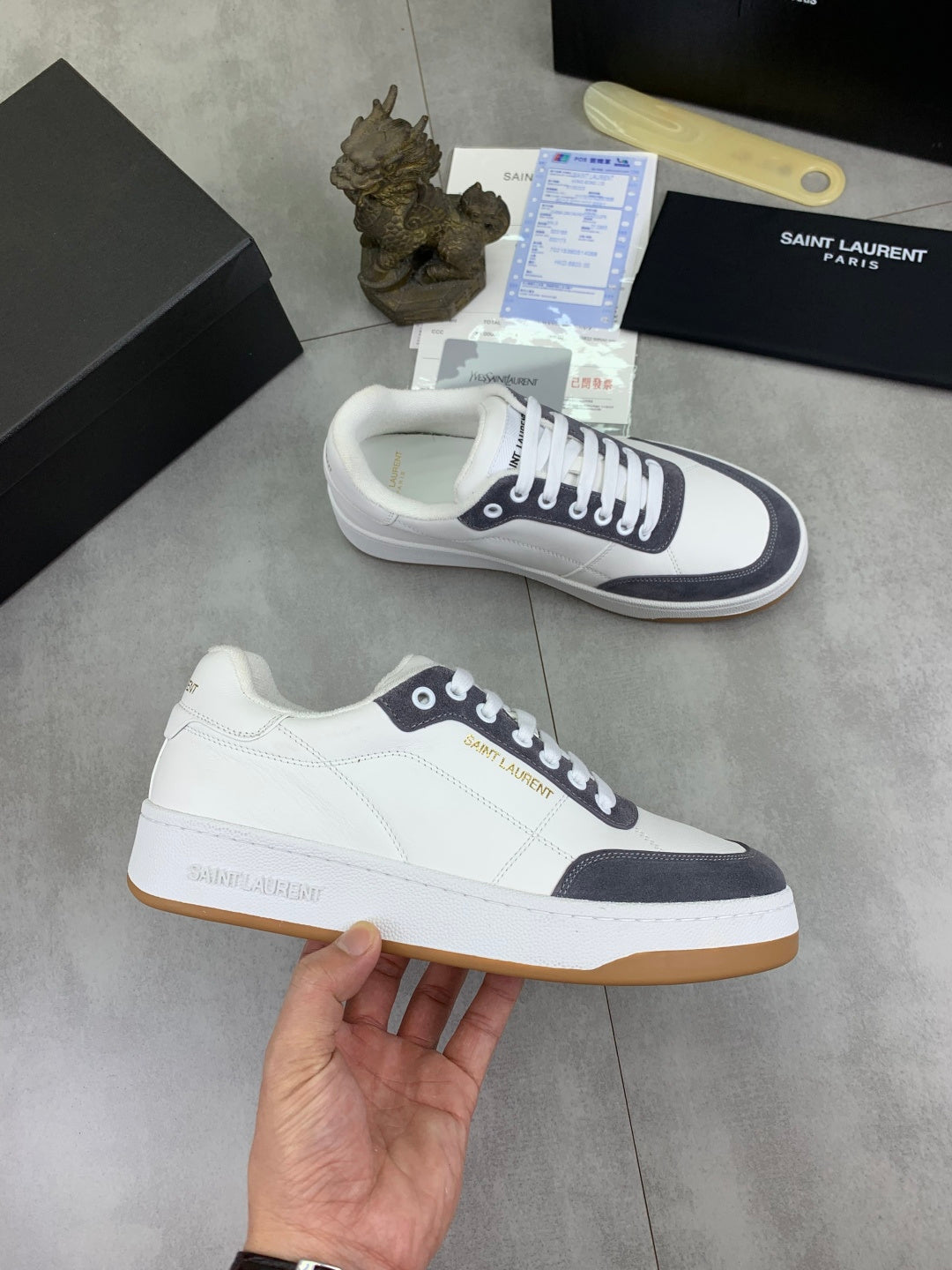 Unisex low-top sneakers held, white uppers with navy accents and gum sole.