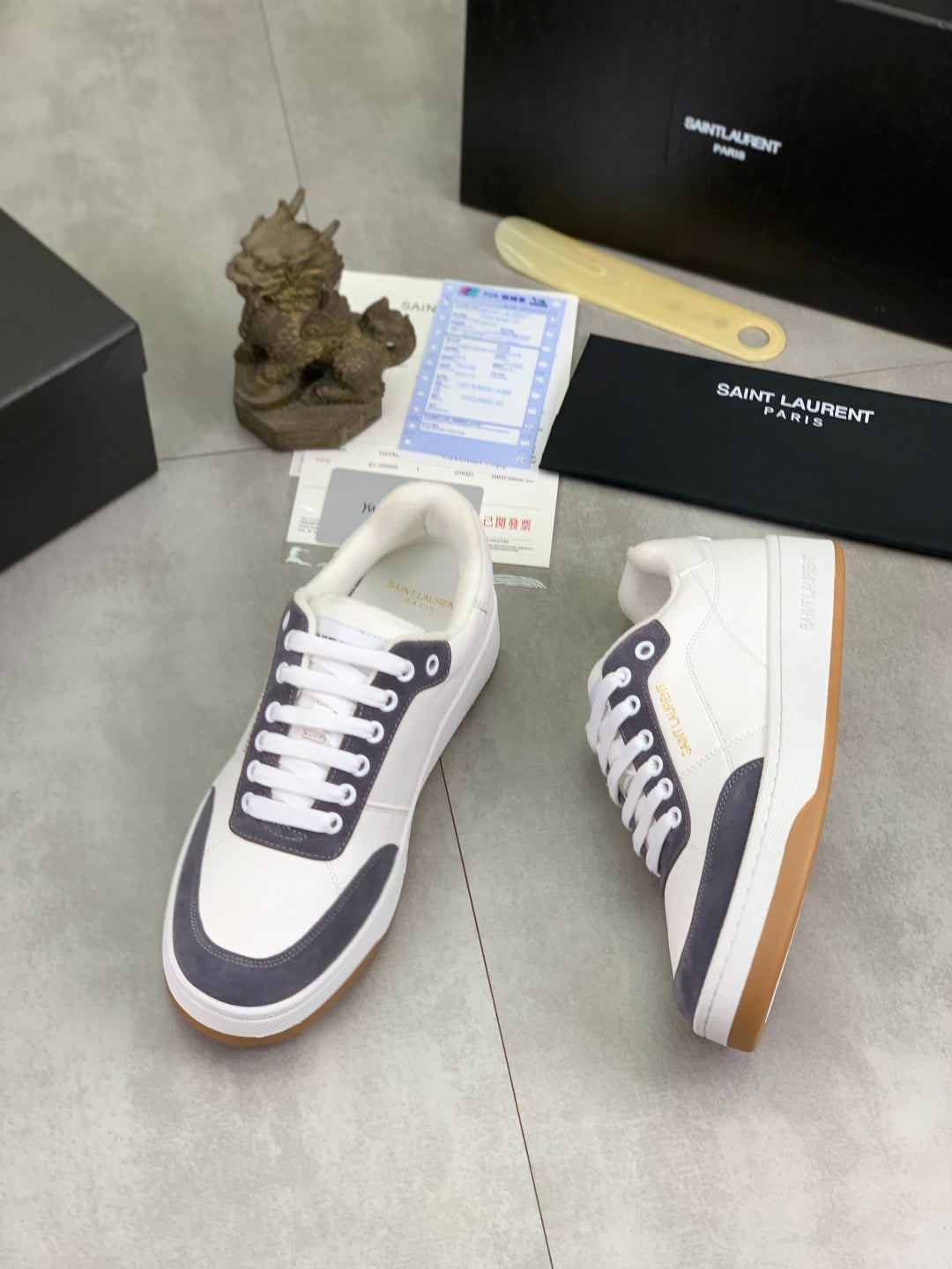 Unisex low-top sneakers, white with navy trim, white laces and gum outsole.