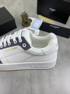 Unisex sneaker heel close-up, white leather with navy collar and logo detail.