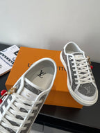 Women’s low-top sneakers, dark monogram upper with white trim and lace-up closure.