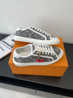 Women’s low-top sneakers, dark monogram front view with white laces and cherry charm.