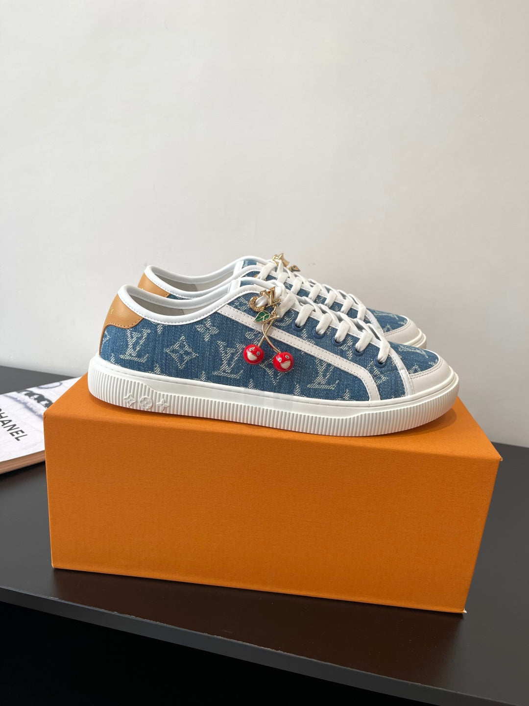 Louis Vuitton low-top sneakers with blue monogram upper, white laces, and red cherry charms