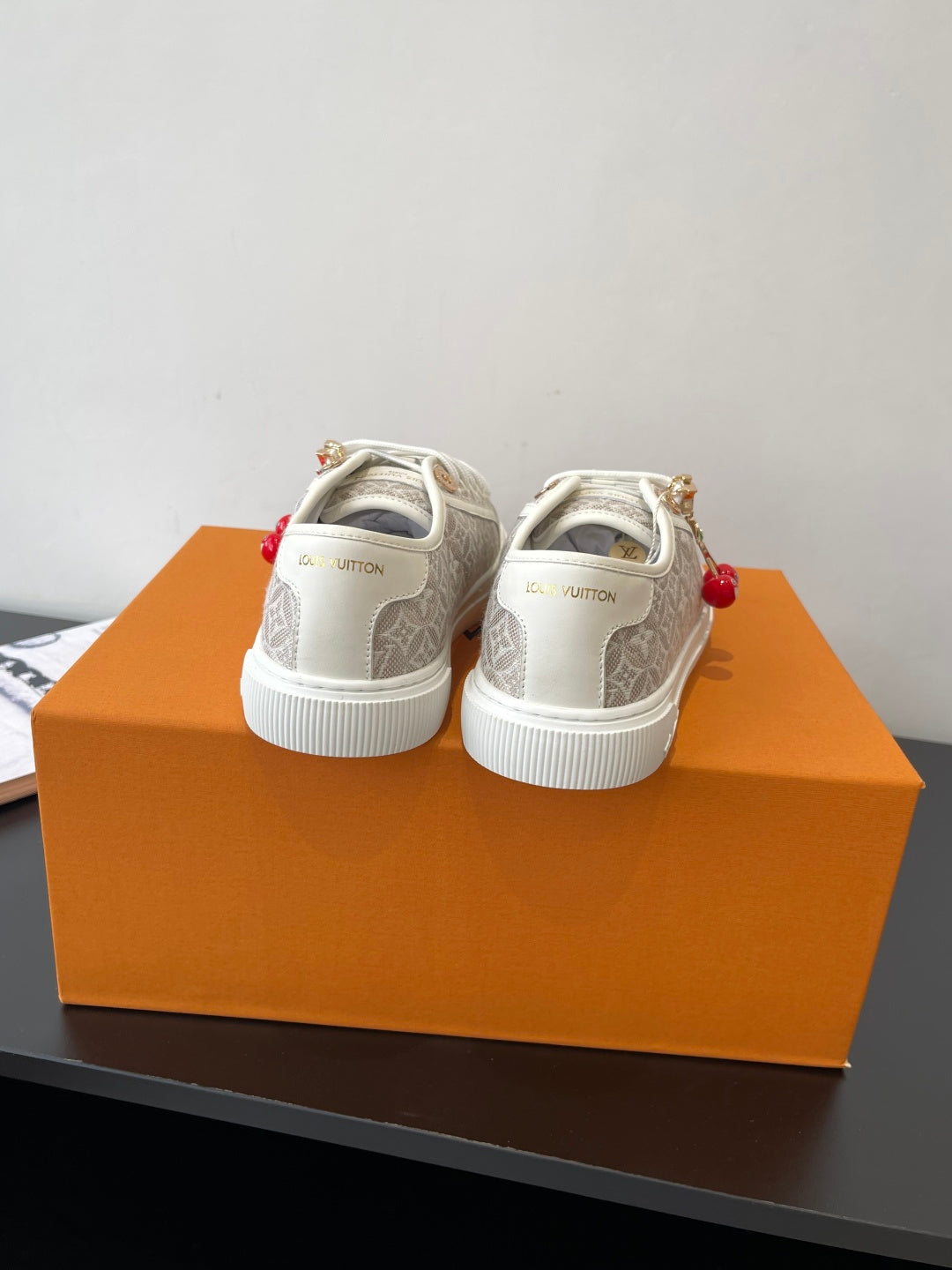 Louis Vuitton ladies sneakers, back view with white rubber sole and gold eyelets