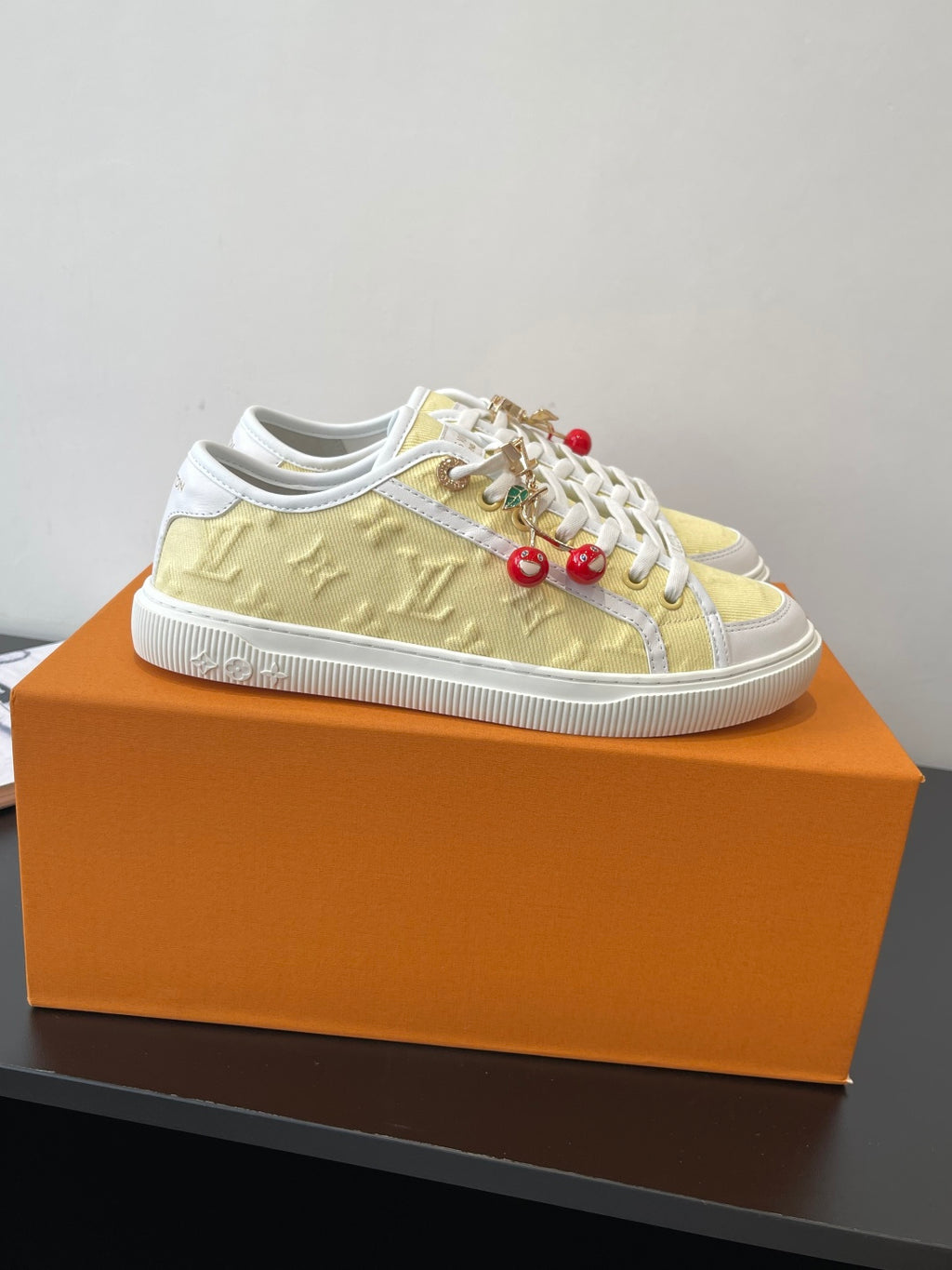 Louis Vuitton low-top sneakers, pale yellow upper with white side stripe and laces