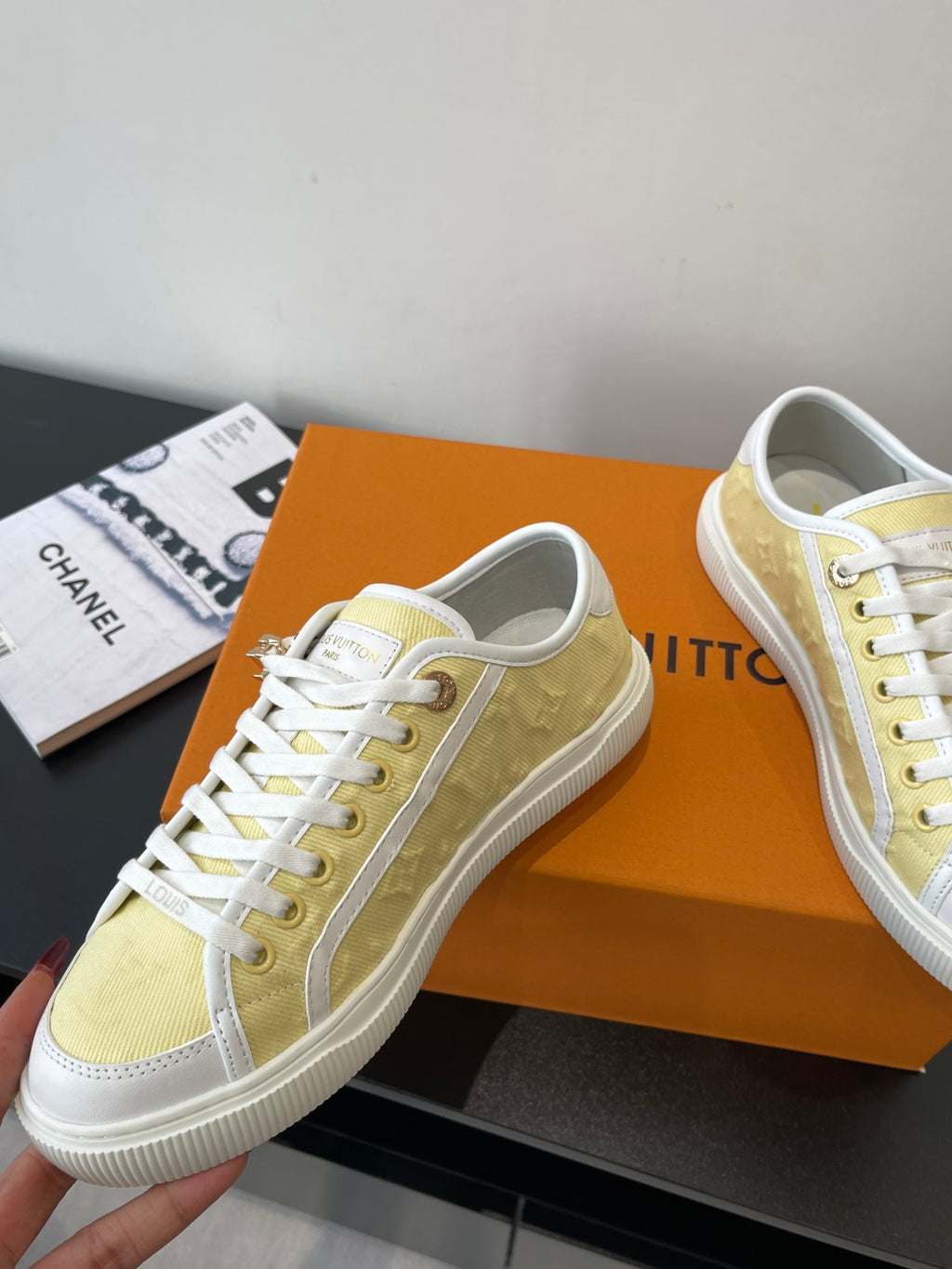 Louis Vuitton low-top sneakers, pale yellow and white with zipper pull and red charms