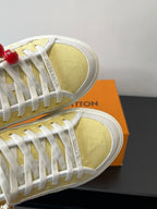 Louis Vuitton low-top sneakers, close-up of yellow toe panel with white laces