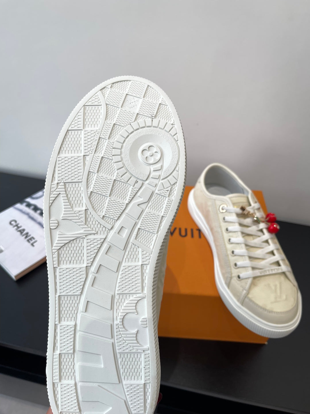 Women's Louis Vuitton sneakers, outsole view with textured tread and beige toe cap.