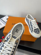 Louis Vuitton ladies sneakers with navy patterned uppers, white laces, red cherry charm detail