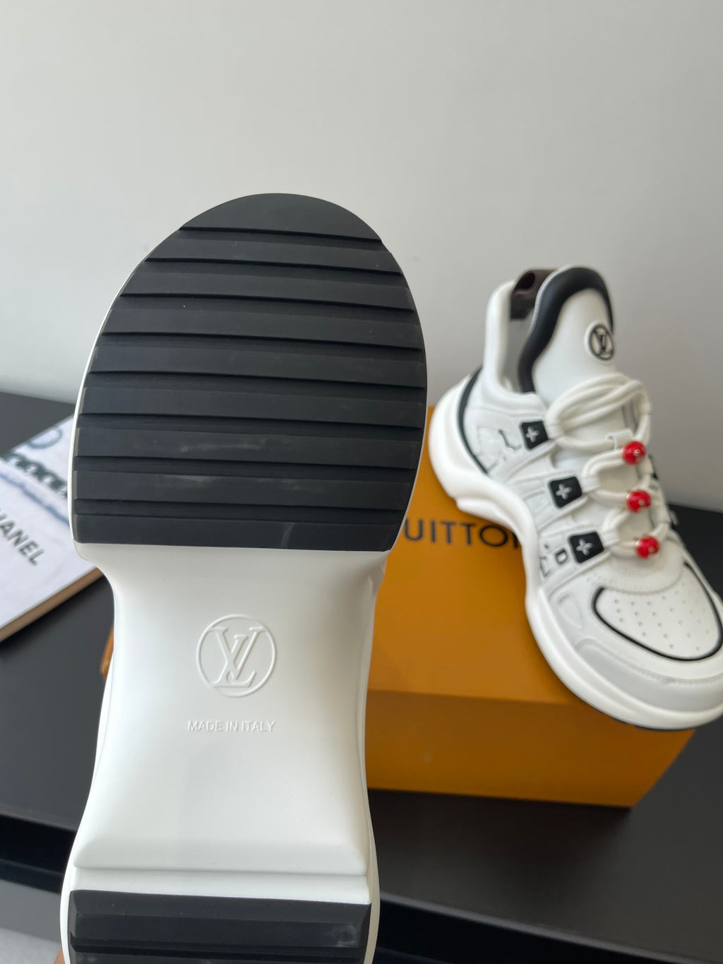 White sneaker outsole with ribbed tread and LV heel emblem