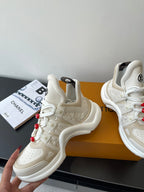 Pair of white lace-up chunky sneakers with red bead lace charms and padded collars