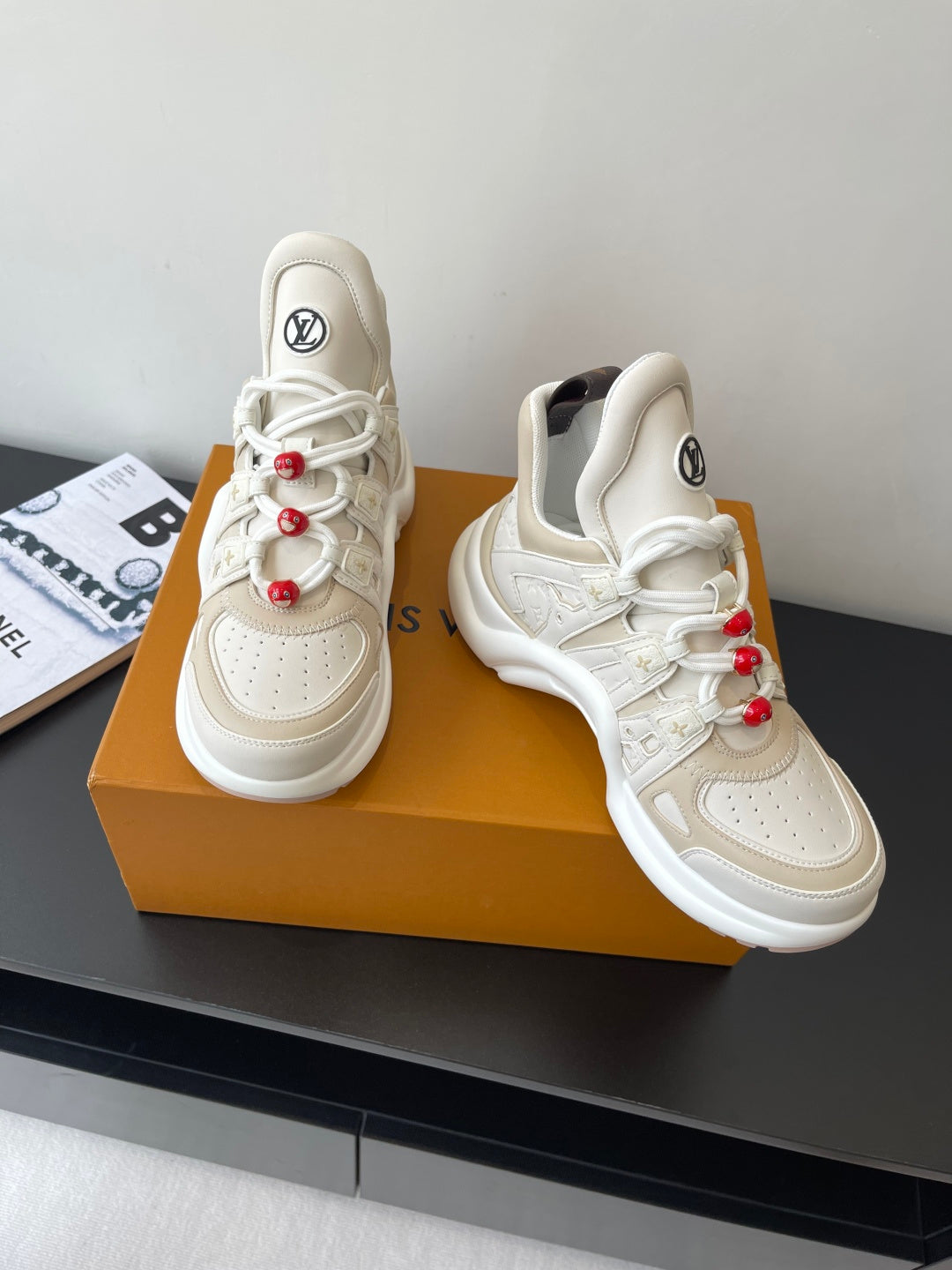 White lace-up chunky sneakers with red bead lace accents and LV logo on tongue
