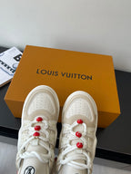 White lace-up sneakers with red bead lace charms, perforated toe and smooth panels
