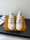 White lace-up sneakers with chunky sole, red bead lace accents, LV logo on tongue