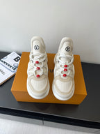 White lace-up sneakers with chunky sole, red bead lace accents, LV logo on tongue