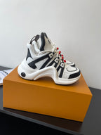 White and black chunky low-top sneakers with red beaded lace accents