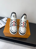 White and black low-top sneakers with black logo details and red beaded laces