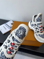 Louis Vuitton women's sneakers close-up, white leather with navy monogram panels