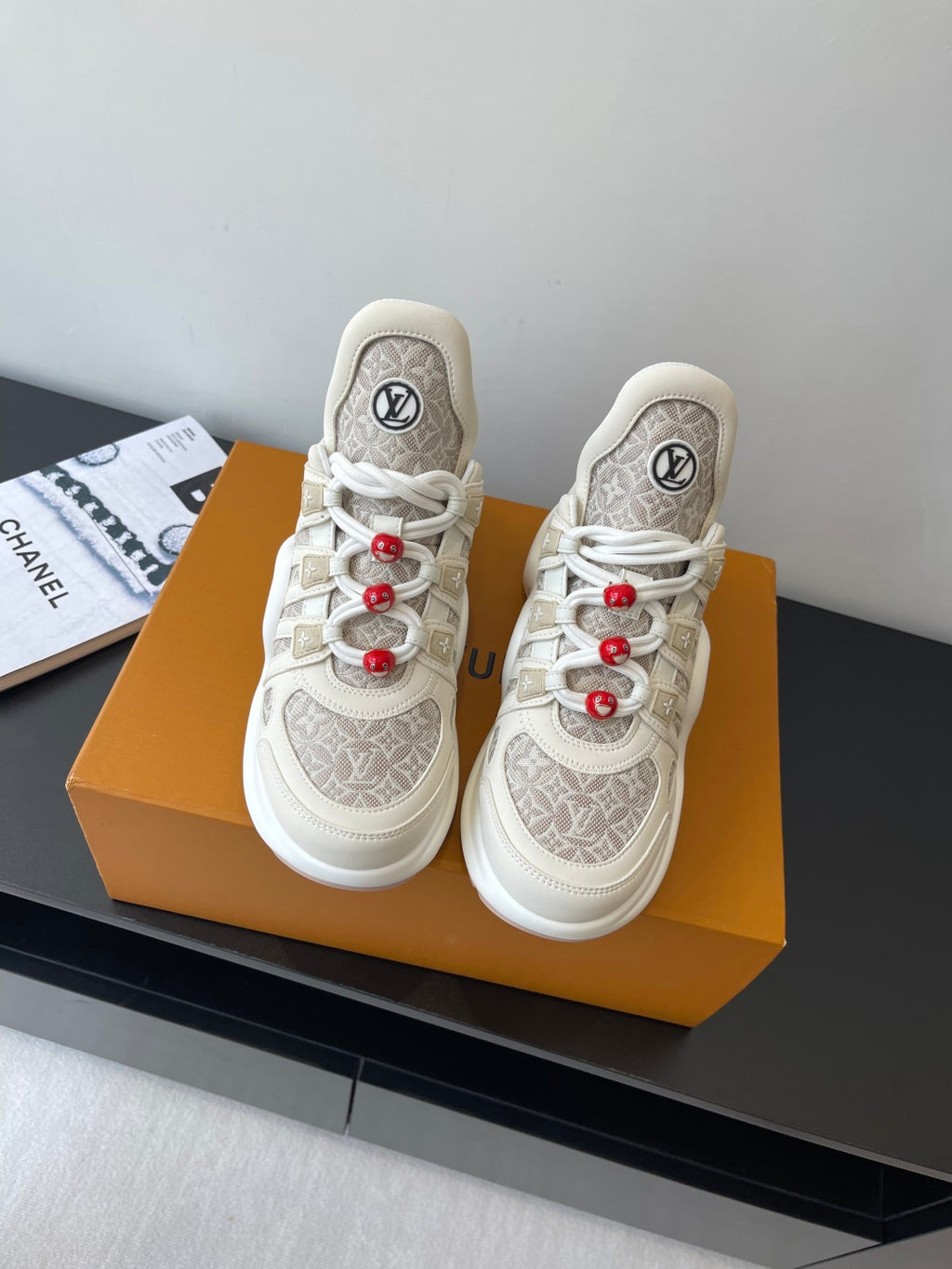 Louis Vuitton low-top sneakers in off-white with monogram pattern and red lace accents
