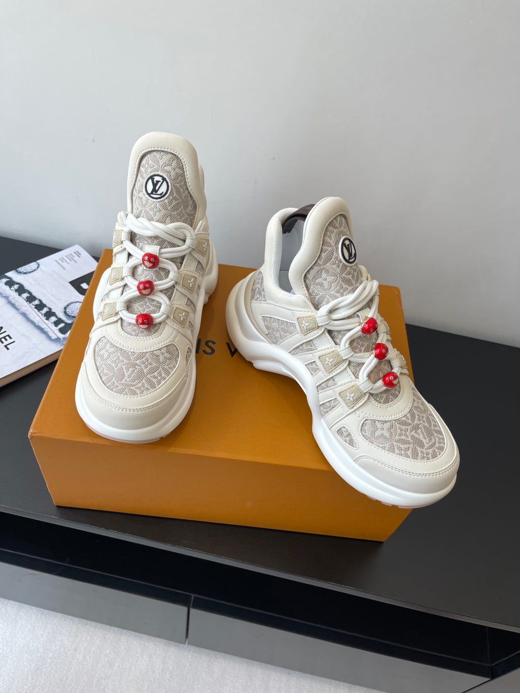 Louis Vuitton low-top sneakers front view, off-white with beige monogram uppers and red laces