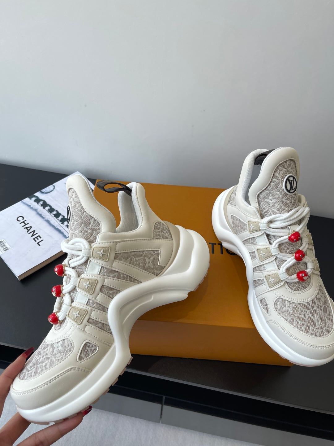 Louis Vuitton low-top sneakers with off-white leather, beige monogram trim, red lace beads