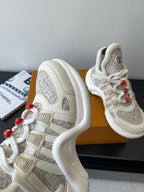Louis Vuitton low-top sneakers side view, off-white with beige monogram straps and red lace beads