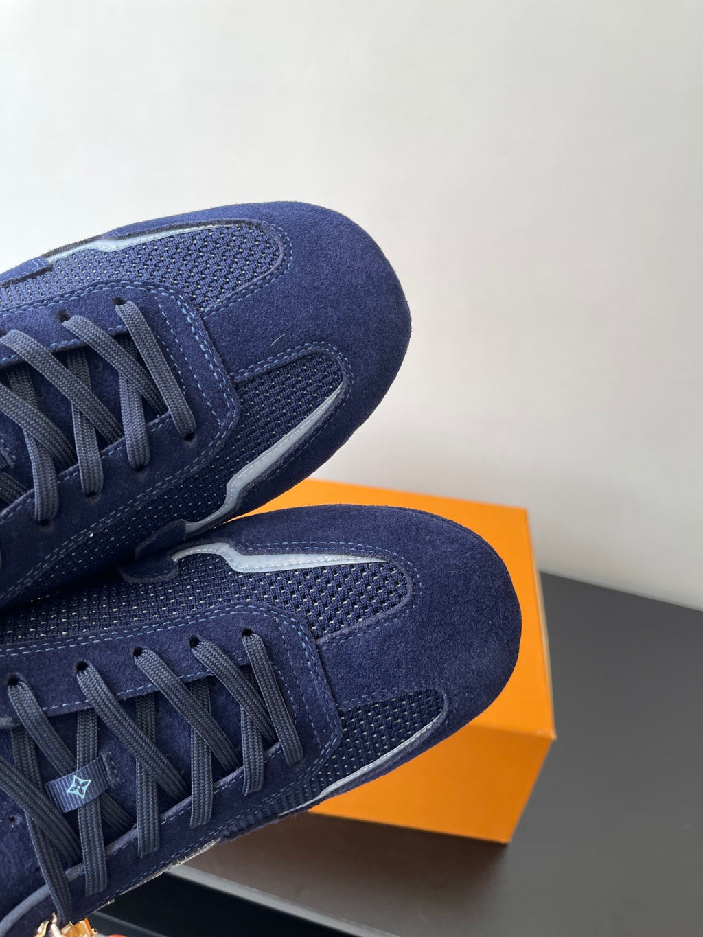 Louis Vuitton ladies navy sneakers, close-up of side panels and lace texture